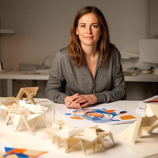 Anna Meier an einem Designtisch mit Prototypen und Papiermustern
